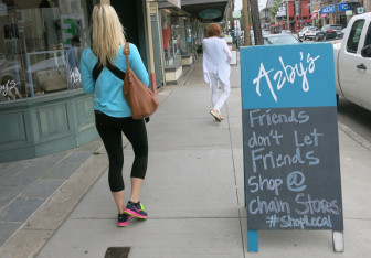 A sign at Azby's, a women's clothing store on Magazine, exhorts people to shop local. On the next block is Chico's, a national women's clothing chain.