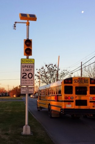 A school bus passes a non-working school flasher on Higgins Boulevard, near the temporary campus for McDonough 42 in the 9th Ward, at 7:10 am on Jan. 8. The solar panel at the top of the pole is supposed to face south; it’s facing east-northeast. The manufacturer says that solar panels must be aligned properly to charge the batteries.