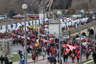 Climate activists parade beneath the Eiffel Tower en route across Paris 