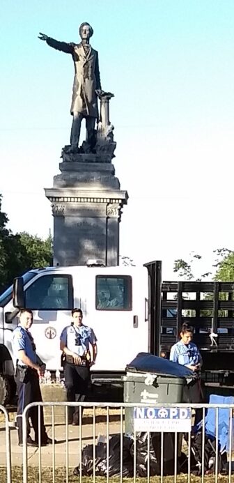 Police barricade Monument to Confederate leader Jefferson Davis, after dueling demonstrations by groups for and against its removal. 