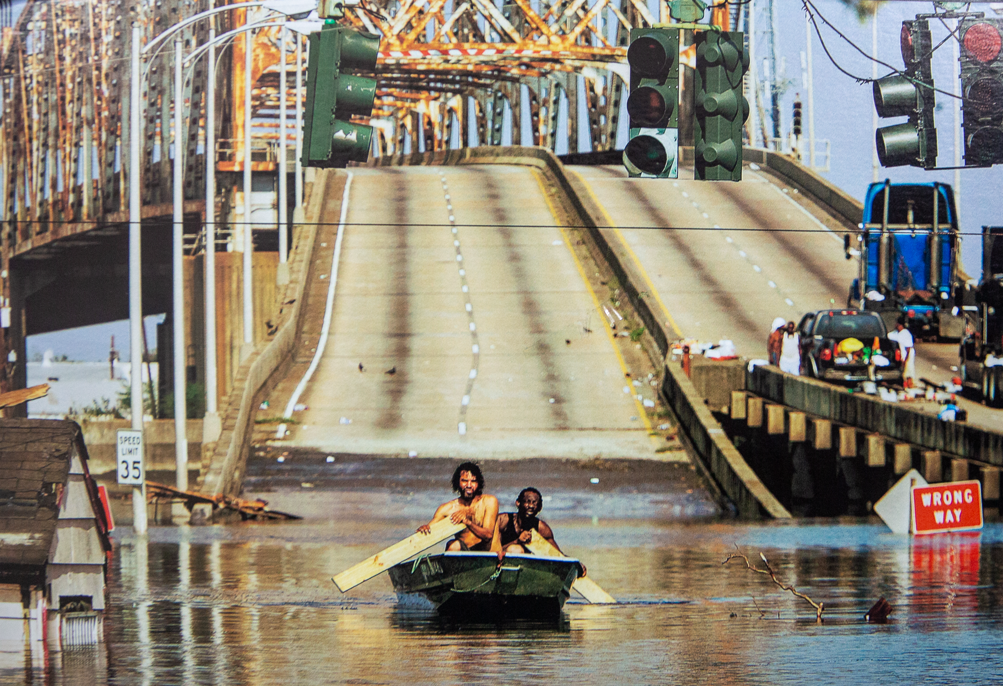 Two men paddle a small boat through floodwaters beside the Claiborne Bridge in New Orleans’ Lower Ninth Ward in 2005.